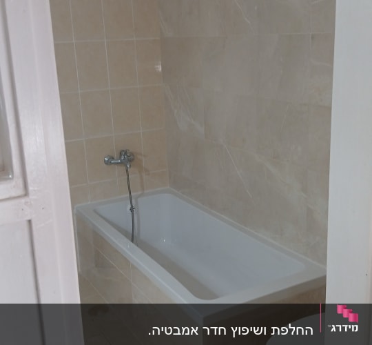 חדר אמבטיה עם אמבטיה חדשה וקירות מרוצפים